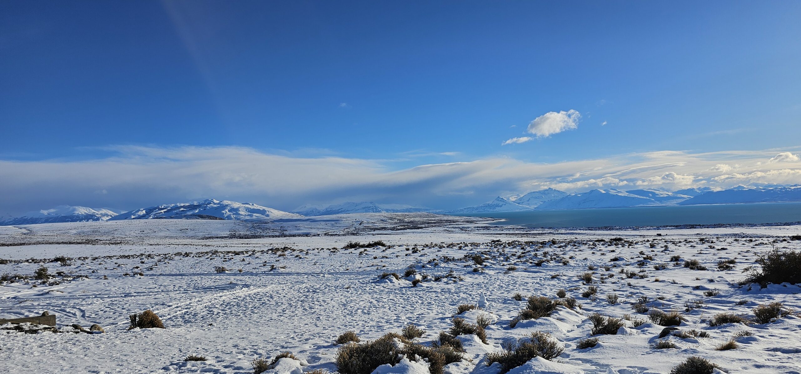 Services Snow-covered mountains and open landscape beneath a clear blue sky